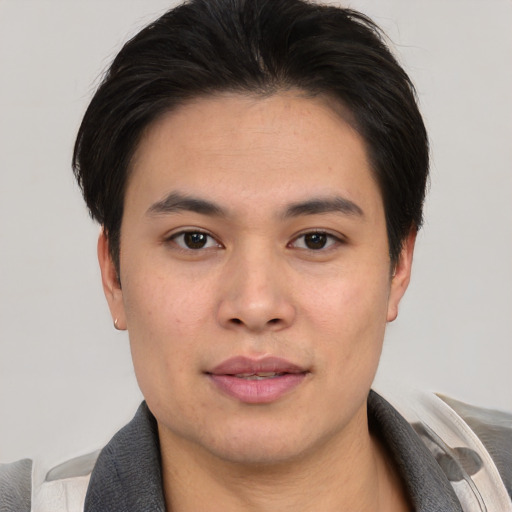 Joyful asian young-adult male with short  brown hair and brown eyes