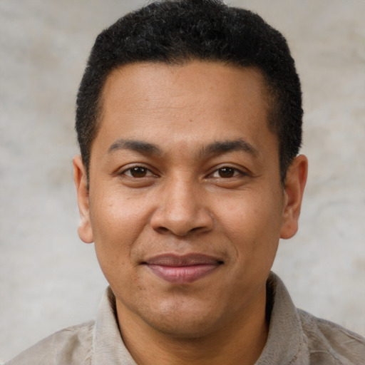 Joyful latino adult male with short  brown hair and brown eyes