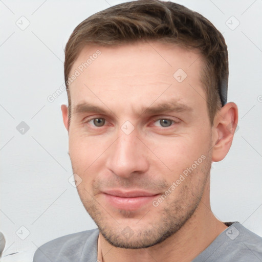 Joyful white young-adult male with short  brown hair and grey eyes