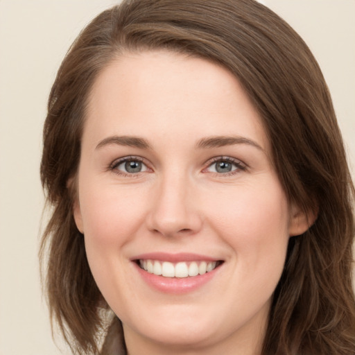 Joyful white young-adult female with long  brown hair and grey eyes