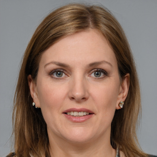 Joyful white young-adult female with medium  brown hair and grey eyes