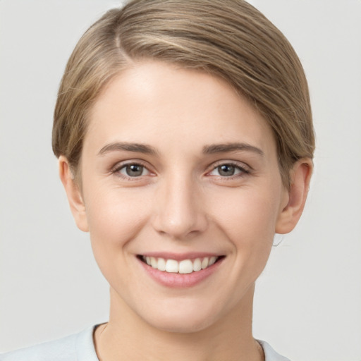 Joyful white young-adult female with short  brown hair and grey eyes