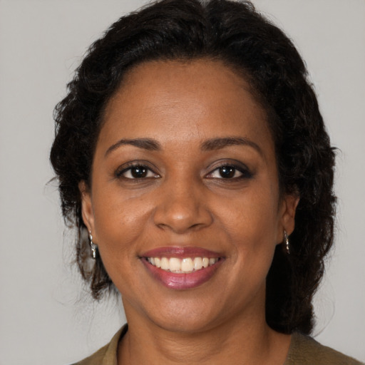 Joyful black adult female with long  brown hair and brown eyes