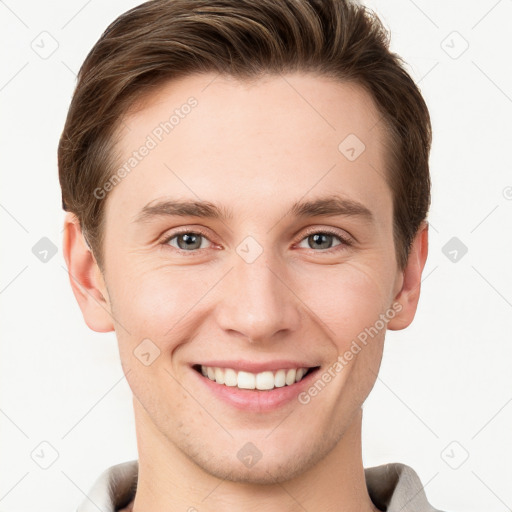 Joyful white young-adult male with short  brown hair and grey eyes