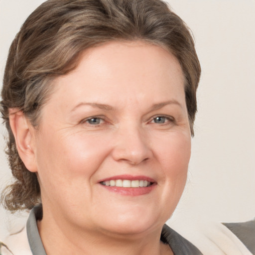 Joyful white adult female with medium  brown hair and grey eyes