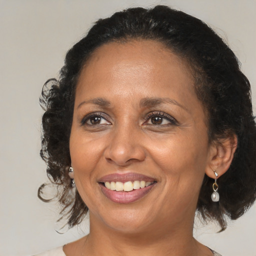 Joyful black adult female with medium  brown hair and brown eyes
