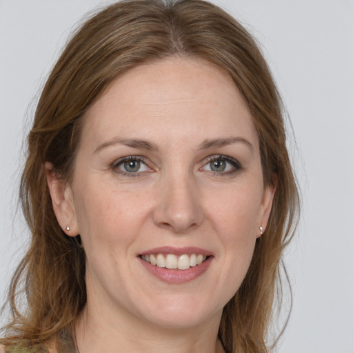 Joyful white adult female with long  brown hair and grey eyes