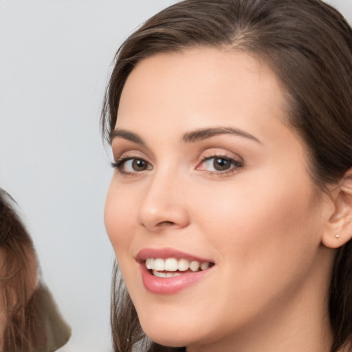 Joyful white young-adult female with long  brown hair and brown eyes