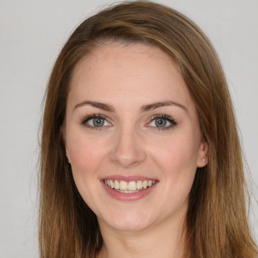 Joyful white young-adult female with long  brown hair and green eyes