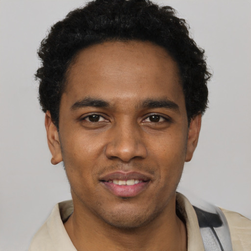 Joyful black young-adult male with short  black hair and brown eyes