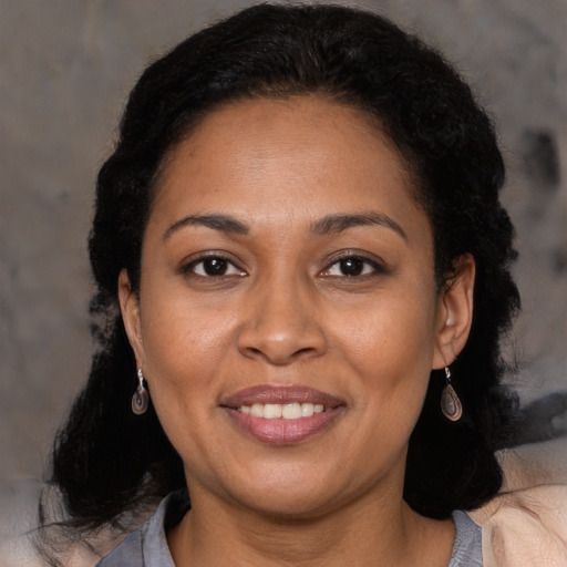 Joyful latino adult female with medium  brown hair and brown eyes
