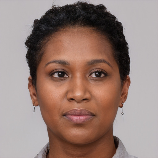 Joyful black young-adult female with short  black hair and brown eyes