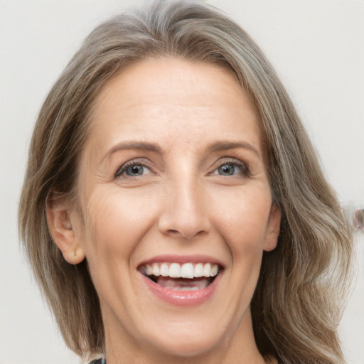 Joyful white adult female with medium  brown hair and grey eyes