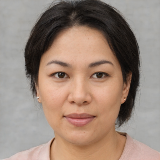 Joyful asian adult female with medium  brown hair and brown eyes