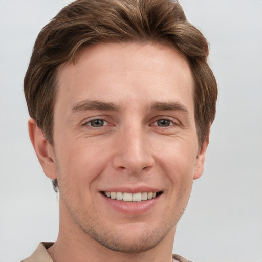 Joyful white young-adult male with short  brown hair and grey eyes