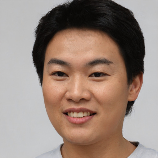 Joyful asian young-adult male with short  black hair and brown eyes