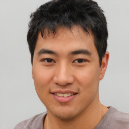 Joyful asian young-adult male with short  black hair and brown eyes