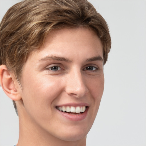 Joyful white young-adult male with short  brown hair and grey eyes