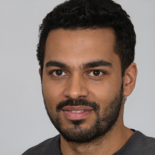 Joyful black young-adult male with short  black hair and brown eyes