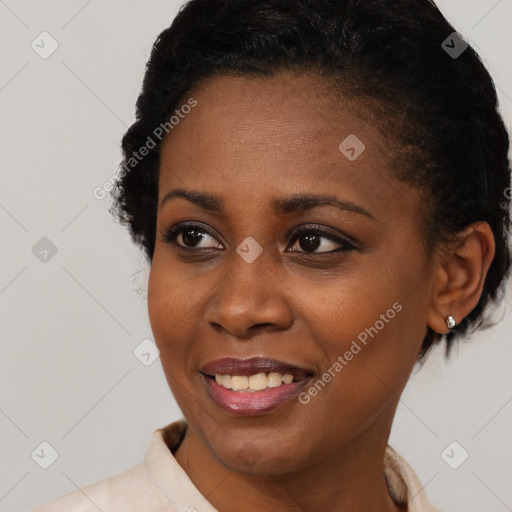 Joyful black young-adult female with short  black hair and brown eyes