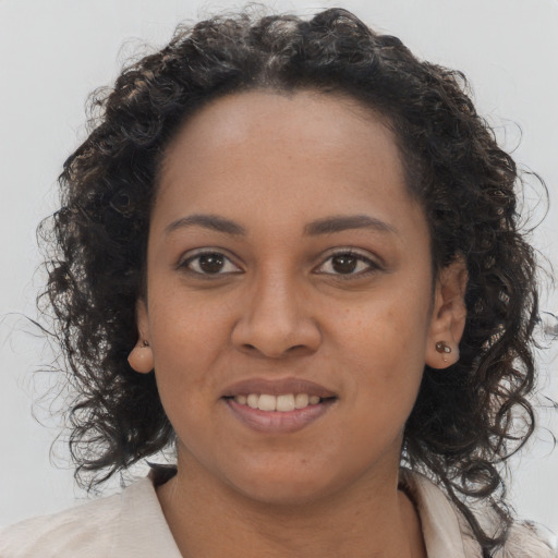 Joyful black young-adult female with long  brown hair and brown eyes