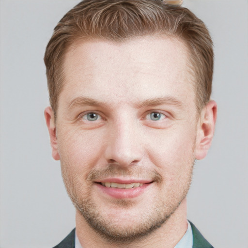 Joyful white young-adult male with short  brown hair and blue eyes