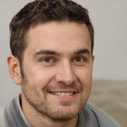 Joyful white adult male with short  brown hair and brown eyes