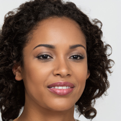 Joyful black young-adult female with long  brown hair and brown eyes