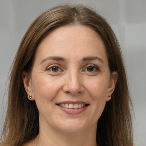 Joyful white adult female with long  brown hair and brown eyes