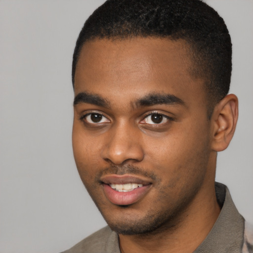 Joyful black young-adult male with short  black hair and brown eyes