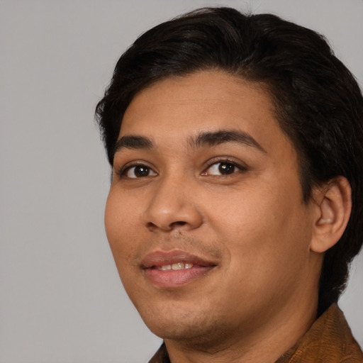 Joyful latino young-adult male with short  brown hair and brown eyes