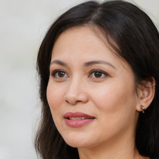 Joyful white adult female with long  brown hair and brown eyes