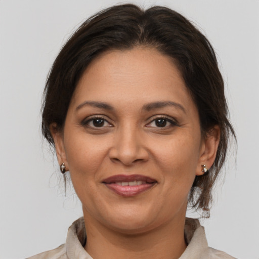 Joyful latino adult female with medium  brown hair and brown eyes