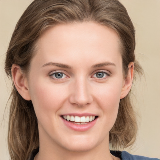 Joyful white young-adult female with long  brown hair and blue eyes