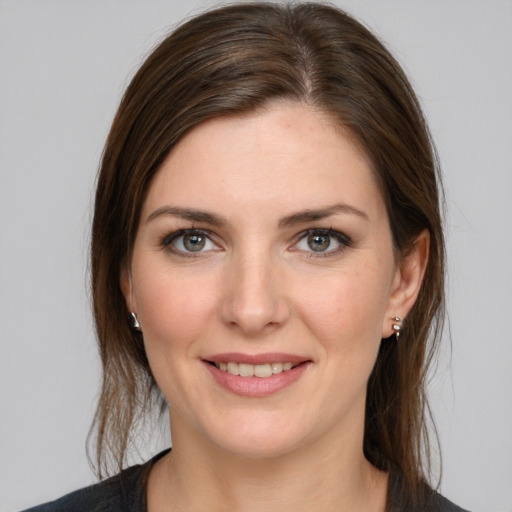 Joyful white young-adult female with medium  brown hair and grey eyes