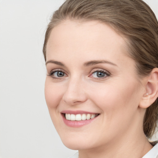 Joyful white young-adult female with medium  brown hair and green eyes