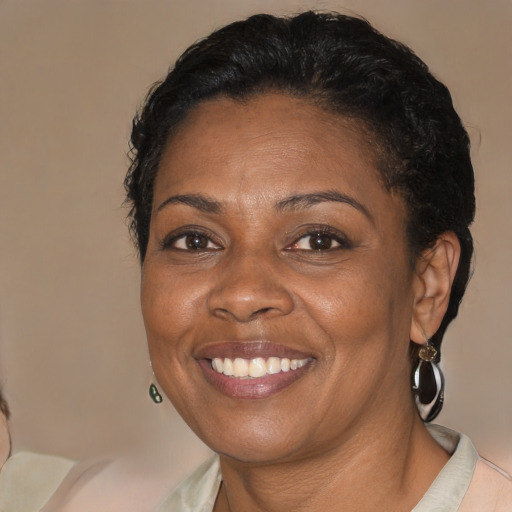 Joyful black adult female with medium  brown hair and brown eyes