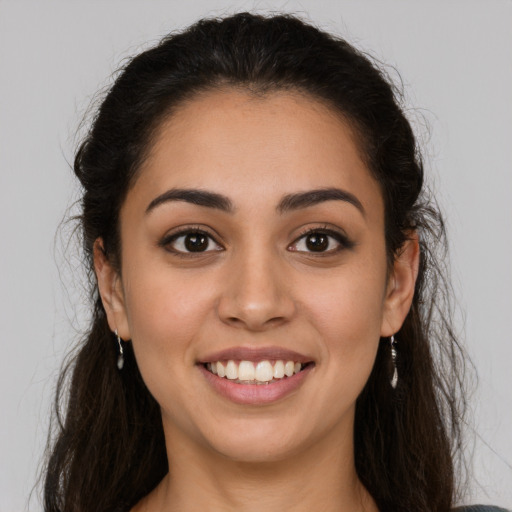 Joyful latino young-adult female with long  brown hair and brown eyes