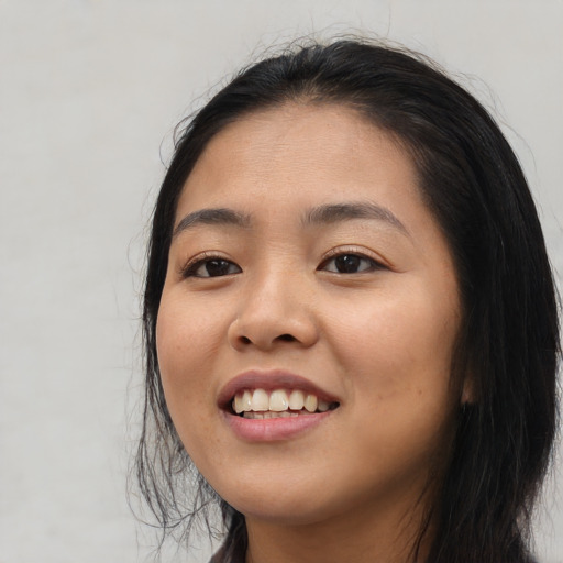 Joyful asian young-adult female with long  black hair and brown eyes