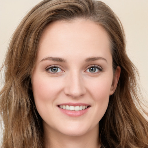 Joyful white young-adult female with long  brown hair and green eyes