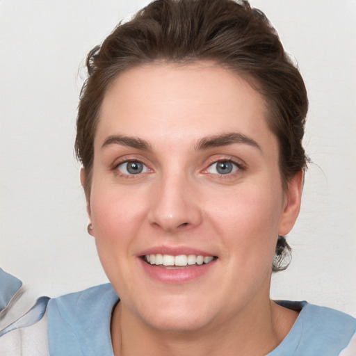 Joyful white young-adult female with short  brown hair and blue eyes