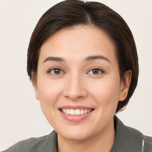 Joyful white young-adult female with short  brown hair and brown eyes