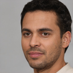 Joyful white young-adult male with short  black hair and brown eyes