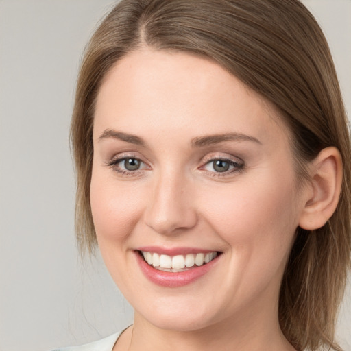 Joyful white young-adult female with long  brown hair and blue eyes