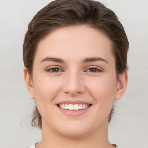 Joyful white young-adult female with short  brown hair and grey eyes