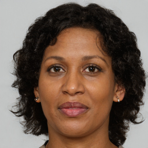 Joyful black adult female with medium  brown hair and brown eyes