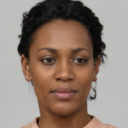 Joyful black young-adult female with short  black hair and brown eyes