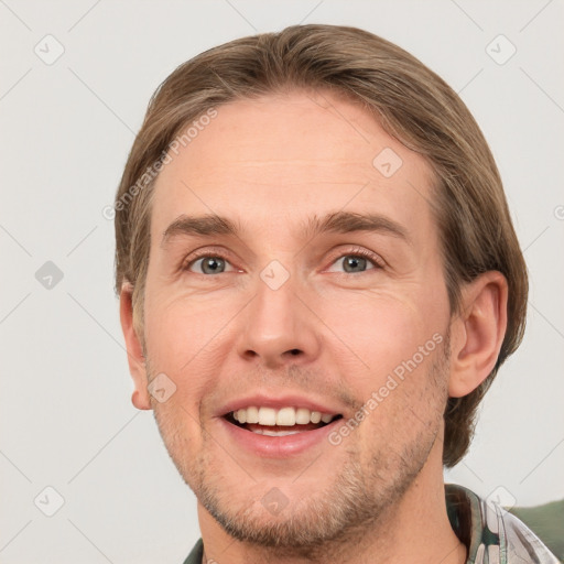 Joyful white young-adult male with short  brown hair and grey eyes