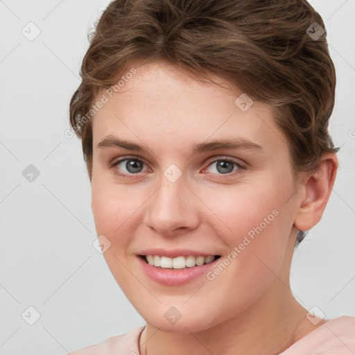 Joyful white young-adult female with short  brown hair and grey eyes