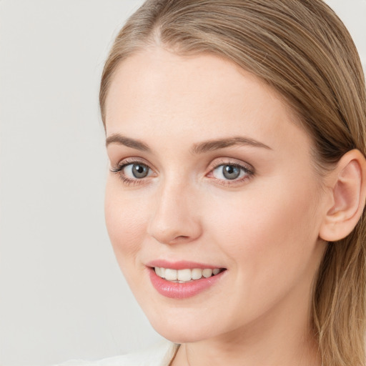 Joyful white young-adult female with long  brown hair and blue eyes